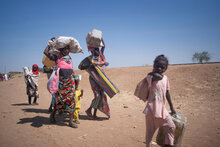 Soudan du sud. Des familles transportent leurs affaires à leur arrivée au Soudan du Sud après avoir fui les combats au Soudan